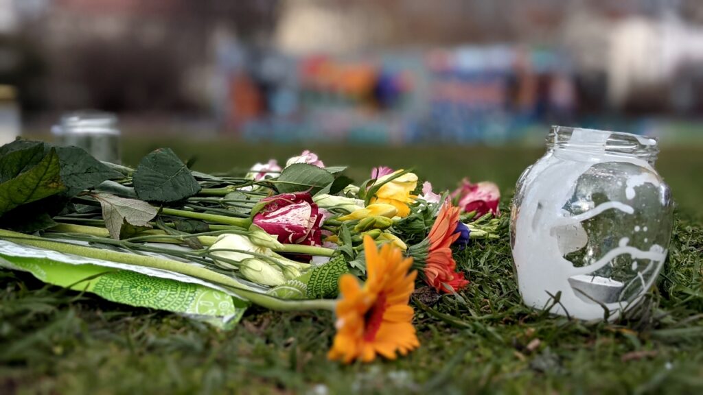 Foto: Kundgebung mit Gedenktafeln: Detail: Blumen